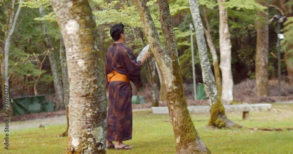 Slide shot of a person wearing a hakama standing in a Japanese garden in Kyoto, Japan 4K slow motion Slide shot of a person wearing a hakama standing in a Japanese garden in Kyoto, Japan 4K slow motion