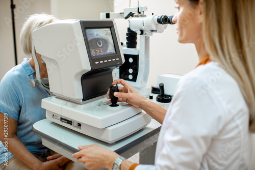 Ophthalmologist examining eyes of a senior patient using digital microscope during a medical examination in the ophthalmologic office