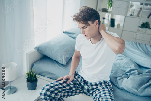 Konstfotografi Portrait of upset unhappy blond hair guy sit on bed wake up feel terrible neck a