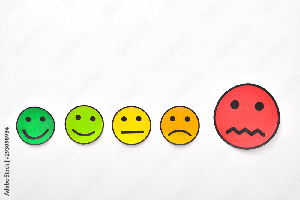 Paper face cutouts on white table highlighting negative rating Paper face cutouts on white table highlighting negative rating