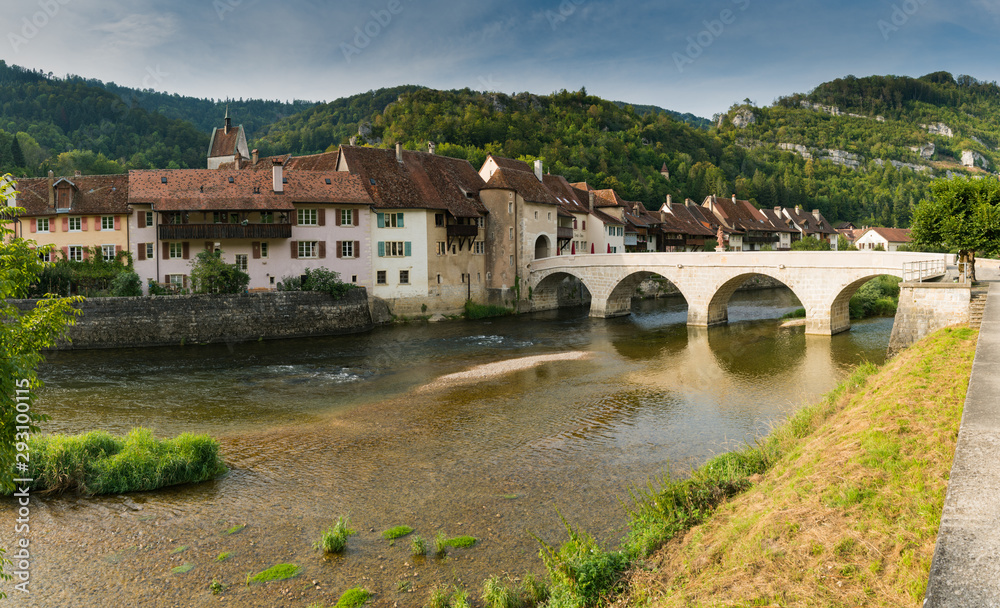panorama view of a picturesque village with old houses in a river and forest landscape in Switzerland