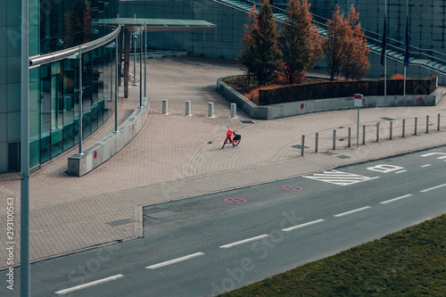 a red electric bike parked outside a building in an empty street closed to cars . Icon of new urban mobility. Green and technology transportation concept photo