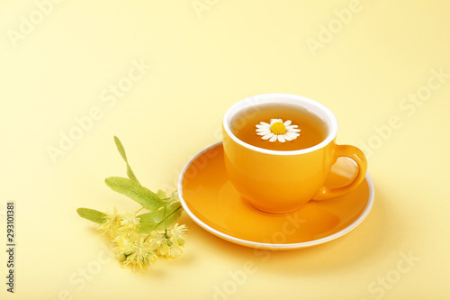 Yellow cup of herbal tea with camomile