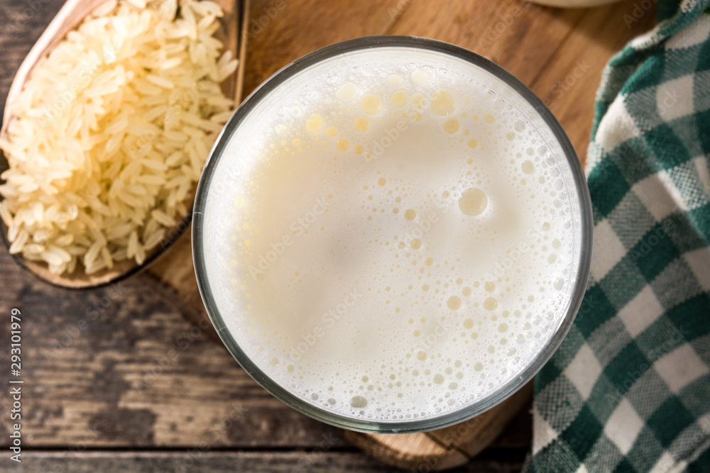 Rice milk in glass and bottle on wooden table. Top view Rice milk in glass and bottle on wooden table. Top view
