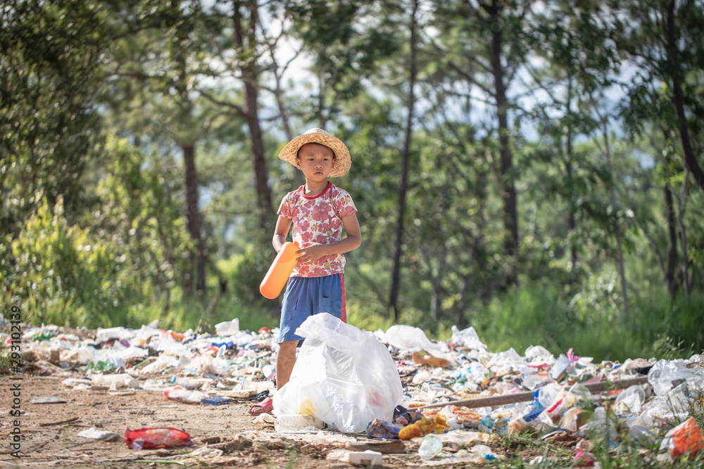 A poor boy collecting garbage waste from a landfill site in the outskirts . children work at these sites to earn their livelihood. Poverty concept. A poor boy collecting garbage waste from a landfill site in the outskirts . children work at these sites to earn their livelihood. Poverty concept.