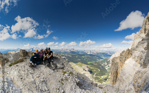 four attractive women mountain climbers hug and smile on a mountain peak after a hard climb together