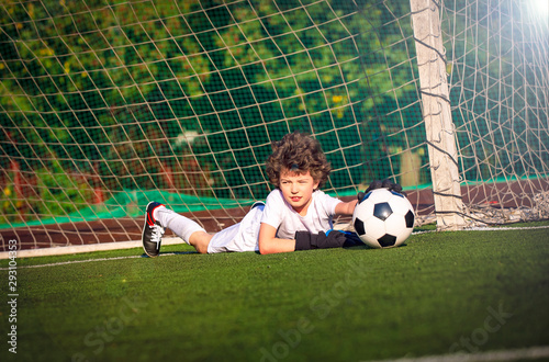 Summer soccer tournament for young kids. football club. emotions and joy of the game. Young goalie. Kids - soccer champion. Boy goalkeeper in football sportswear on stadium with ball. Sport concept.