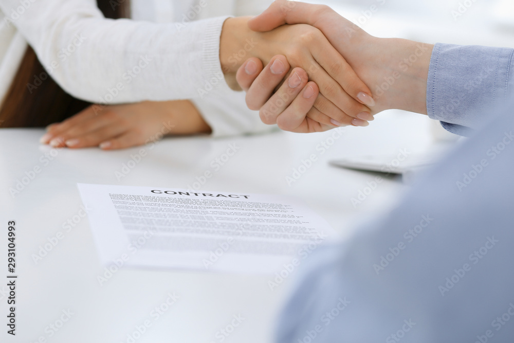 Business people shaking hands at meeting or negotiation after contract discussing. Businessman and woman handshake at office while sitting at the desk. Success concept Business people shaking hands at meeting or negotiation after contract discussing. Businessman and woman handshake at office while sitting at the desk. Success concept