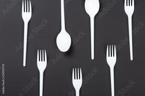 Plastic forks and spoons on gray background