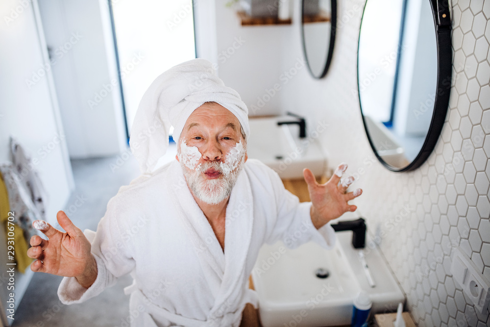 A senior man doing morning routine in bathroom indoors at home. A senior man doing morning routine in bathroom indoors at home.