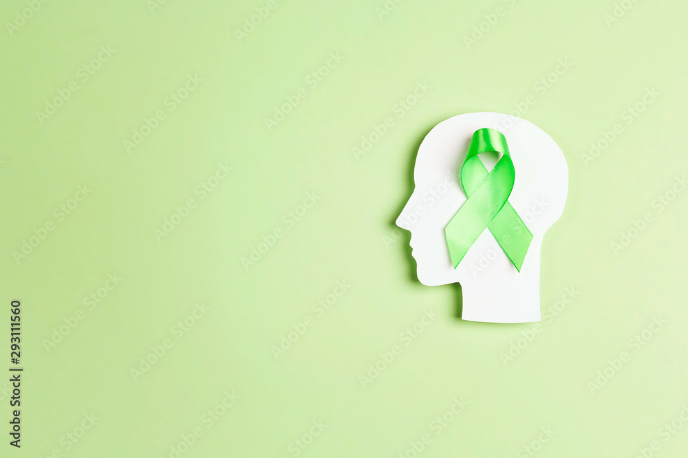 World mental health day concept. Green awareness ribbon with brain symbol on a green background. World mental health day concept. Green awareness ribbon with brain symbol on a green background.