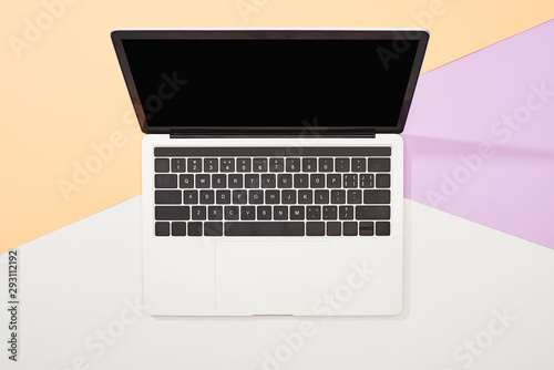top view of laptop with blank screen on beige, violet and white background