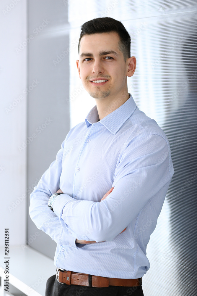 Businessman standing and looking at camera in office. Headshot of casual dressed guy Businessman standing and looking at camera in office. Headshot of casual dressed guy