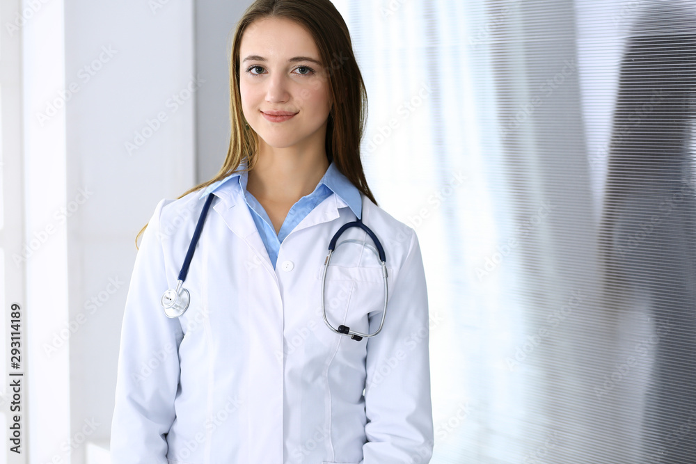 Doctor woman happy and cheerful while standing in hospital office at highlight background. Medicine and healthcare concept Doctor woman happy and cheerful while standing in hospital office at highlight background. Medicine and healthcare concept