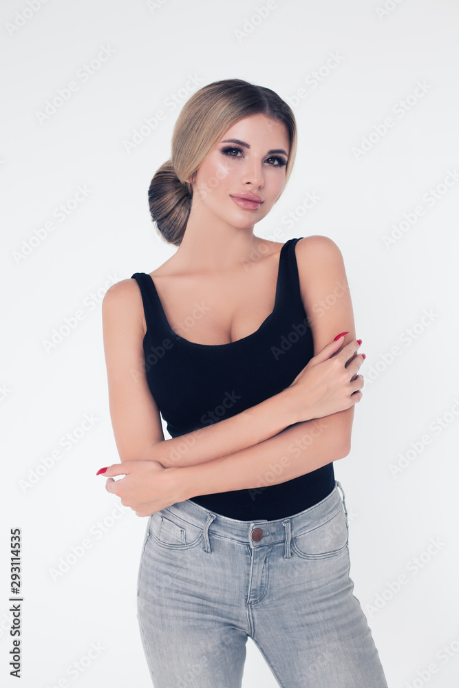 Pretty blonde woman with crossed arms standing against white wall background Pretty blonde woman with crossed arms standing against white wall background