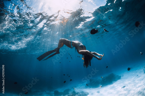 Woman freediver with fins underwater. Freediving and beautiful light in ocean © artifirsov