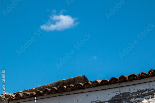 Roof and a bright blue sky with a cloud