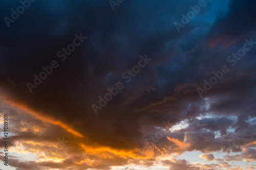 Storm clouds at sunset in orange and blue colors