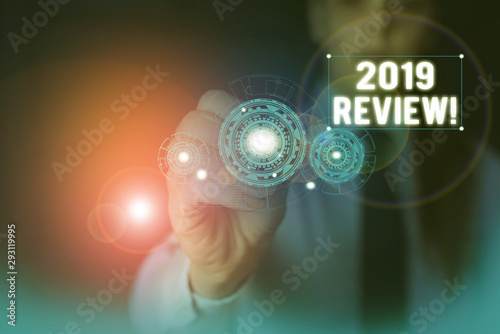 Text sign showing 2019 Review. Business photo showcasing remembering past year events main actions or good shows Woman wear formal work suit presenting presentation using smart device photo