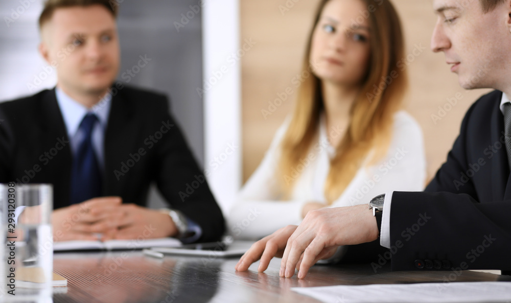 Business people or lawyers discussing questions of contract at meeting in modern office, close-up. Unknown businessman and woman with colleague sitting and working at the glass desk. Teamwork and Business people or lawyers discussing questions of contract at meeting in modern office, close-up. Unknown businessman and woman with colleague sitting and working at the glass desk. Teamwork and