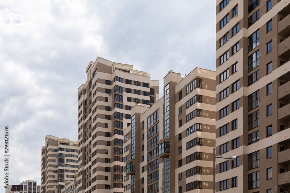 High modern luxury apartment in downtown, brown and beige tiled facade. Sky background, diagonal view, angle view, ground view.