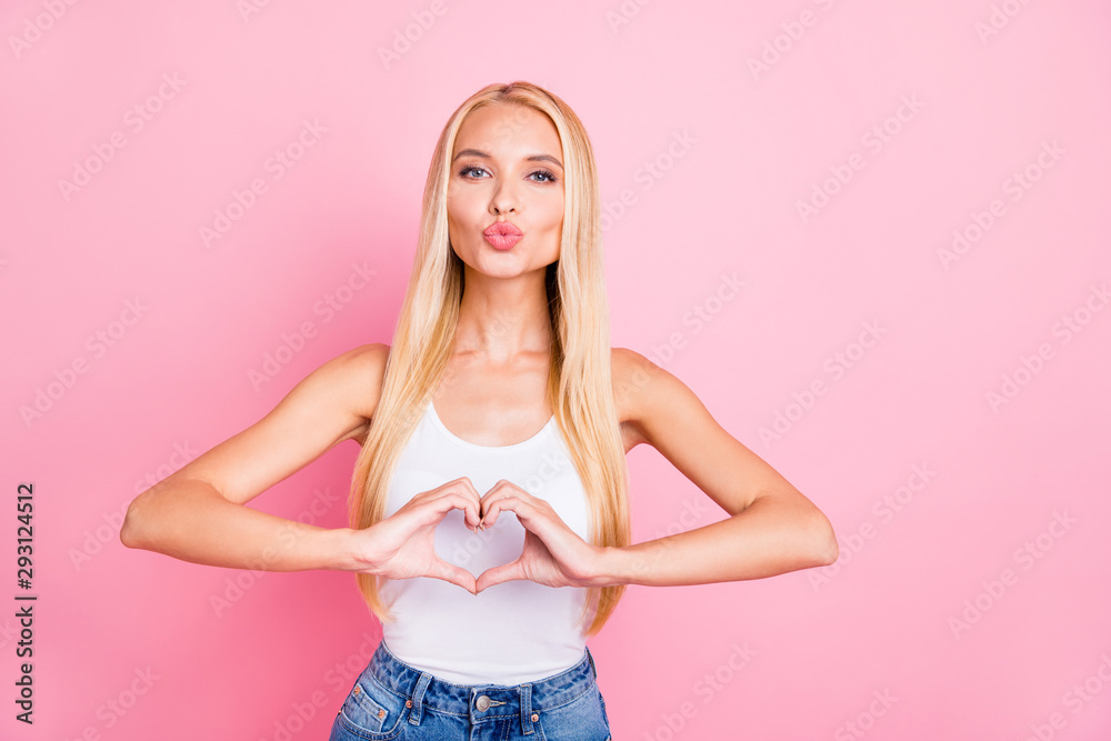 Photo of pretty lady showing heart symbol with hands expressing positive attitude sending air kiss wear casual outfit isolated pink color background Photo of pretty lady showing heart symbol with hands expressing positive attitude sending air kiss wear casual outfit isolated pink color background