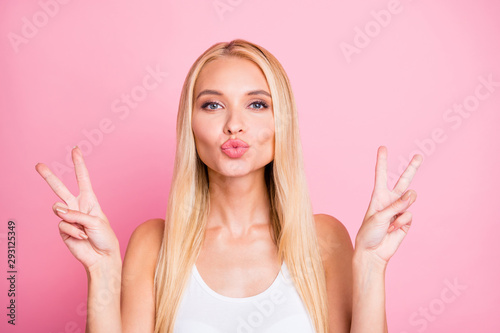 Photo of pretty lady showing v-sign symbols sending air kisses to friends wear casual outfit isolated on pink color background photo
