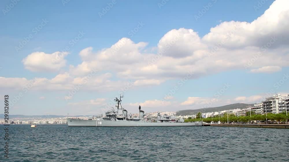 Decommissioned old warship on the coast of Thessaloniki city, Greece, clouds over blue sky and residential buildings Decommissioned old warship on the coast of Thessaloniki city, Greece, clouds over blue sky and residential buildings