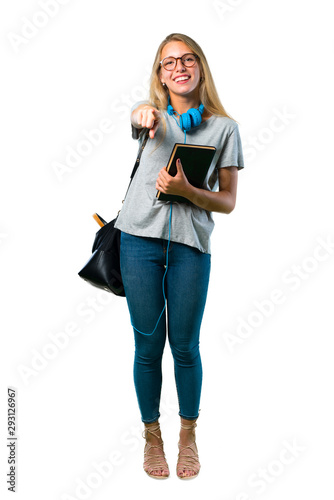 A full-length shot of Student girl with glasses pointing with finger at someone and laughing a lot on isolated white background
