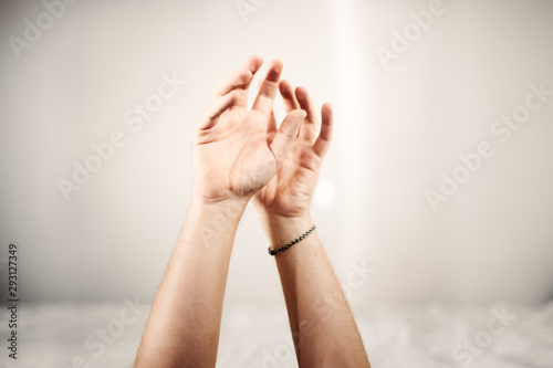 Hände vor weißer Wand vor Bett in Positionierung photo