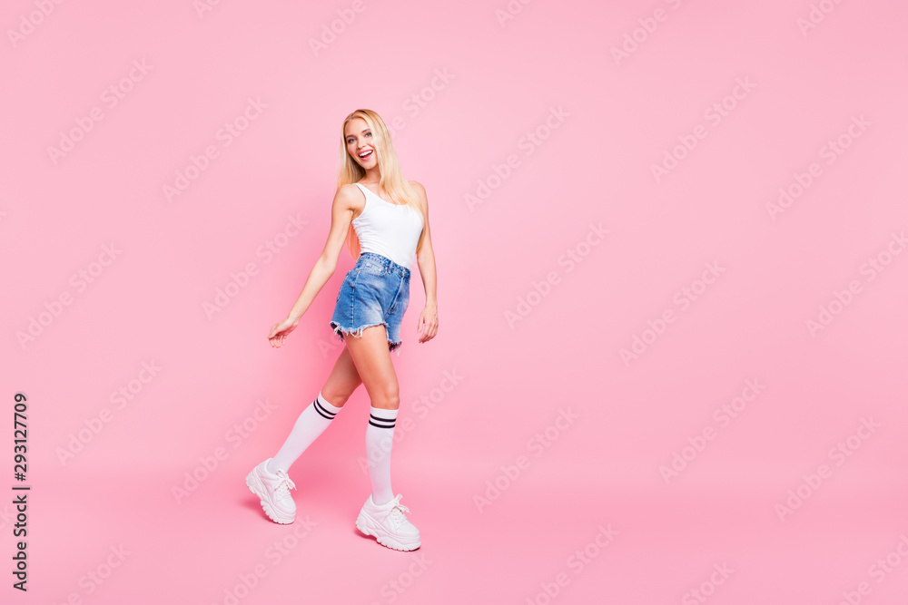 Full body photo of funky lovely girl have promenade walk wear white tank-top shorts denim jeans isolated over pink color background Full body photo of funky lovely girl have promenade walk wear white tank-top shorts denim jeans isolated over pink color background