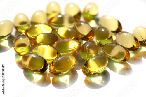 Capsules with fish oil, vitamins A and D. Closeup of a pile of gold vitamins, gold liver oill.