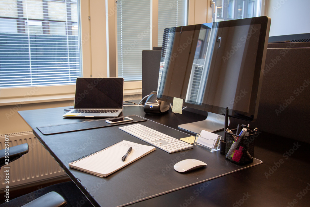 Naklejka premium Office desk with paper and pen. Laptop with external screen.