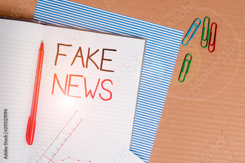 Writing note showing Fake News. Business concept for Giving information to showing that is not true by the media Striped paperboard notebook cardboard office study supplies chart paper photo