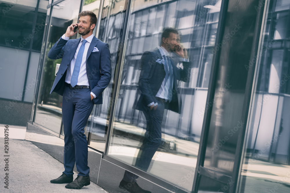 Businessman walking along windows in office corridor Businessman walking along windows in office corridor