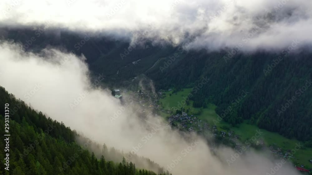 Aerial Forward: Picturesque Village in Cloudy Valley Under Snowy Mountains - Mount Blanc, France Aerial Forward: Picturesque Village in Cloudy Valley Under Snowy Mountains - Mount Blanc, France