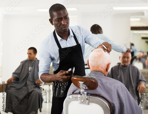 African hairdresser cutting with clipper