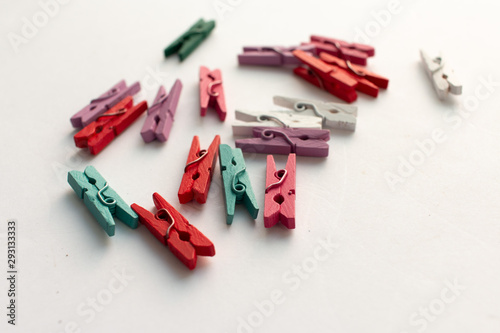 Pile of scattered clothes pegs isolated on white background