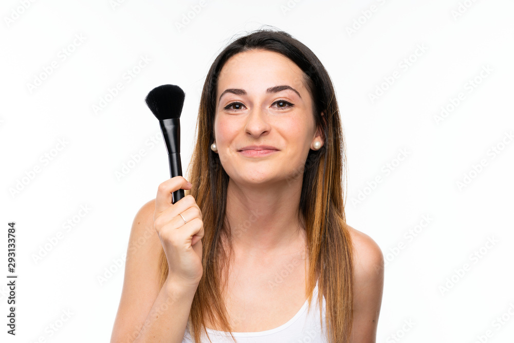 Young woman holding a lot of makeup brush over isolated white background Young woman holding a lot of makeup brush over isolated white background