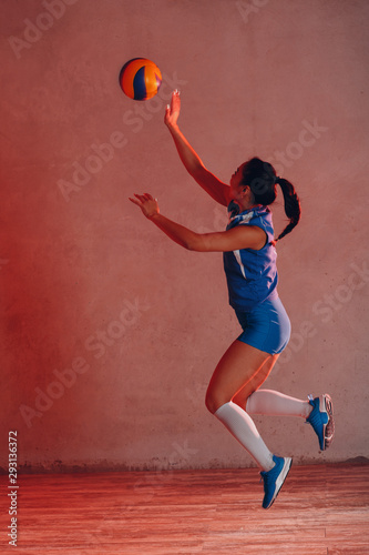 Young Asian woman volleyball player in blue uniform innings ball © primipil