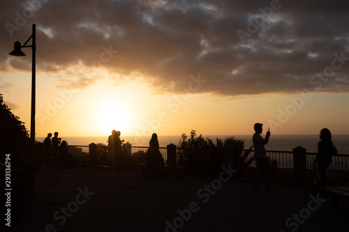Silhouettes of people at beautiful sunset. Puerto de la Cruz, Tenerife, Canary Islands, Spain.