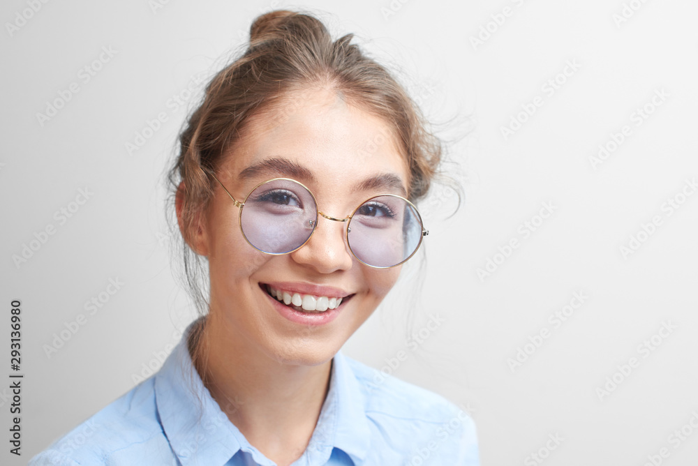 Portrait of a cheerful asian kazakh young woman in stylish glasses dressed casual smiling joyfully isolated on a white background Portrait of a cheerful asian kazakh young woman in stylish glasses dressed casual smiling joyfully isolated on a white background