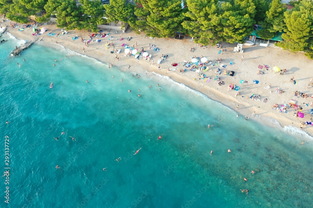 An aerial shot of people enjoying the summer at the beach at daytime 