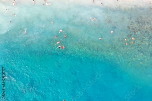 An aerial shot of people enjoying the summer at the beach at daytime  © Omar