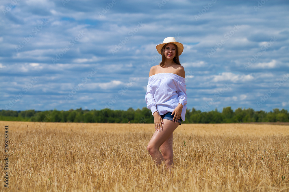 Young brunette woman in white shirt and blue jeans shorts