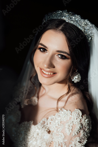 Portrait of smiling beautiful bride. Elegant young woman with perfect makeup and hair style in a white robe. Beauty fashion portrait with accessories