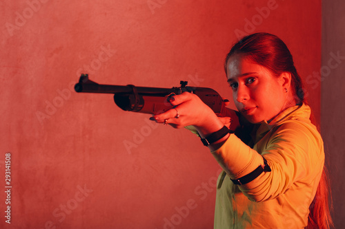 Wallpaper Mural Young woman with rifle aims to target. Self defence concept. Torontodigital.ca