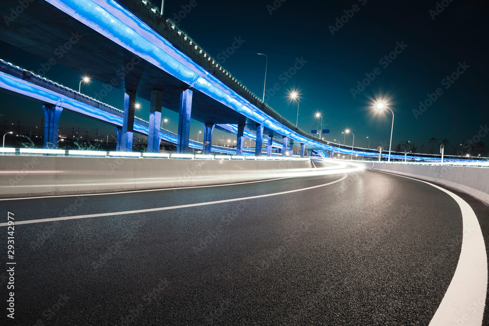 Empty road floor with city viaduct bridge of neon lights night