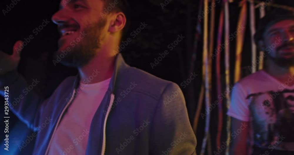 Handsome hipster guy laughing enjoying dance in circle of friends on cool modern summer night party event. Handsome hipster guy laughing enjoying dance in circle of friends on cool modern summer night party event.