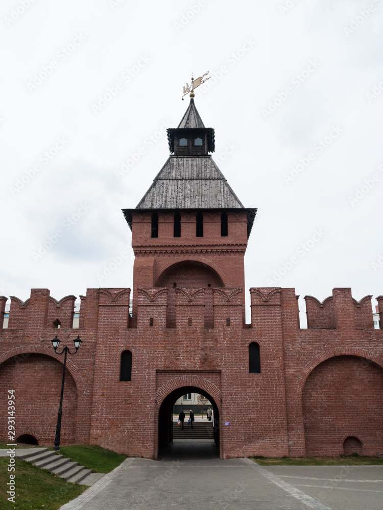 Fototapeta premium widok na wieżę Kremla z bramą łukową. przestrzeń miejska. obszar promenady. czerwona cegła, drewniany dach dwuspadowy, iglica